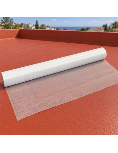 Rollo de malla de fibra de vidrio parcialmente desplegado sobre una terraza impermeabilizada en rojo teja